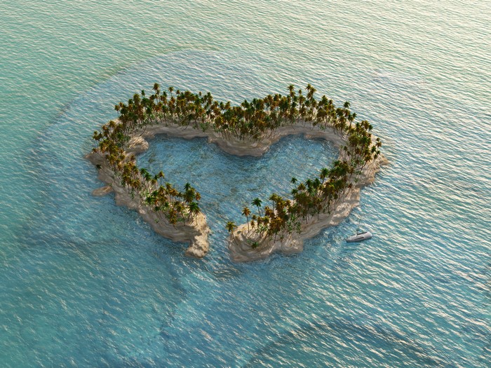 Heart-shaped island with palm trees and a boat