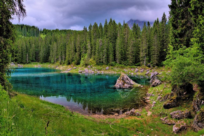 Turquoise lake surrounded by spruce forest and rocks