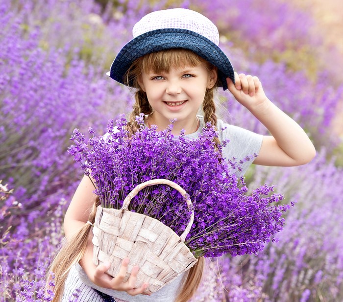 Girl in a hat holding a basket of lavender