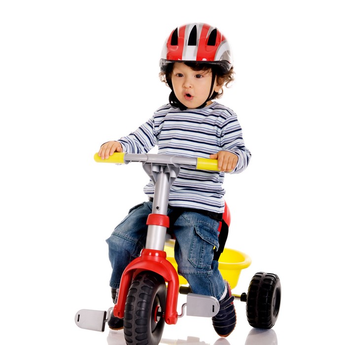 Boy wearing a helmet on a tricycle