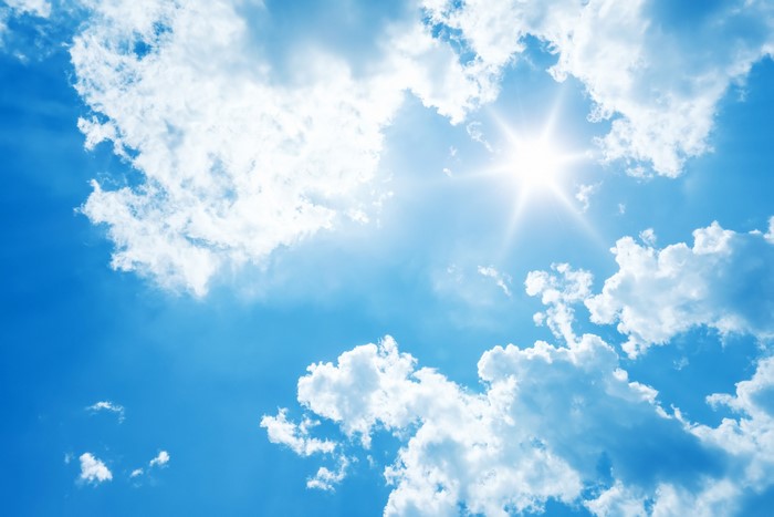 Blue sky with sun and clouds