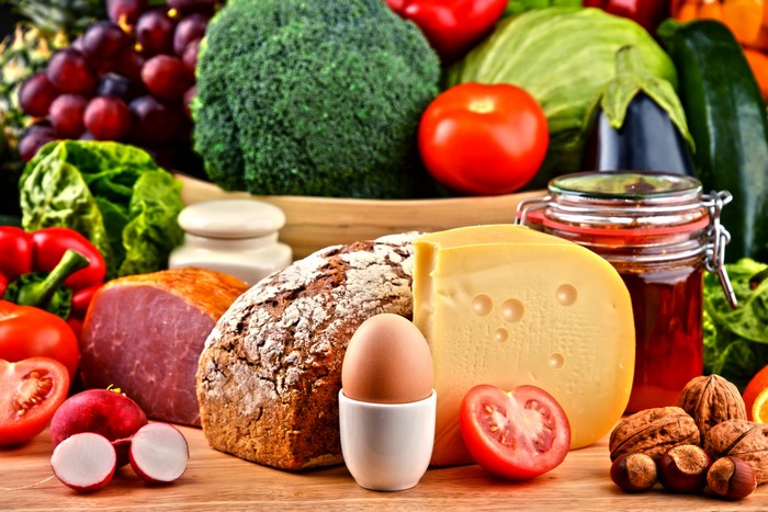 Still-life of food: vegetables, bread, cheese, ham, eggs, nuts, and jam
