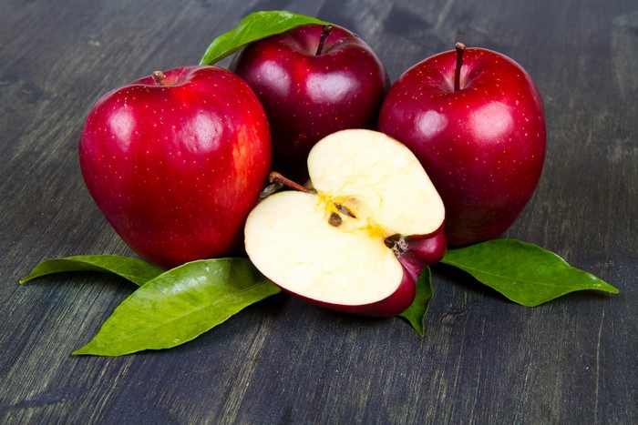 Red Apples with Leaves on Dark Wood