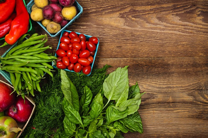 Assortment of fresh vegetables and fruits on a wooden table