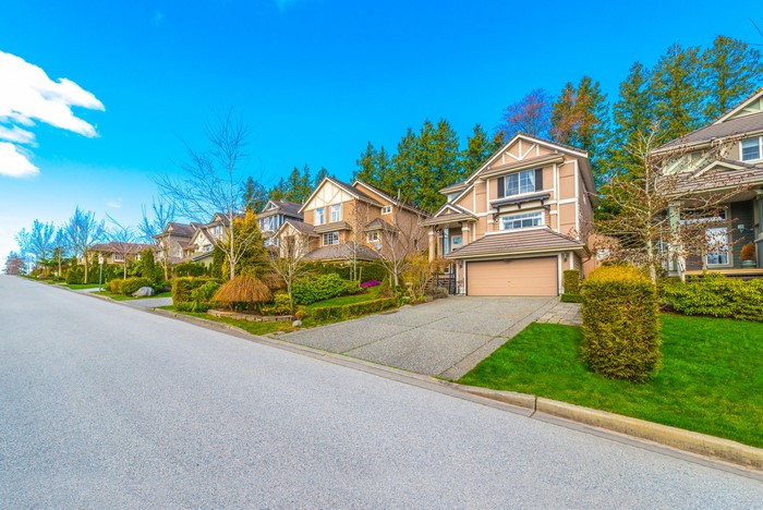 Suburban street with houses and manicured lawns