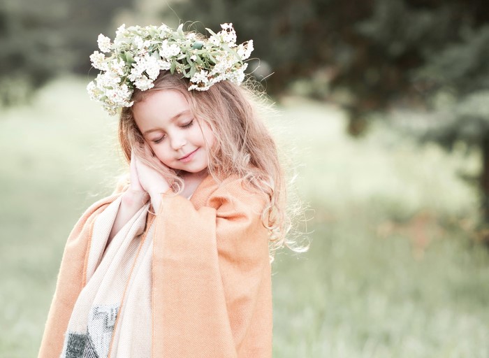 Young girl with flower crown and blanket