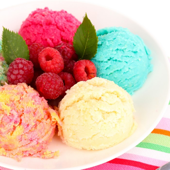 Scoops of ice cream with raspberries and mint leaves