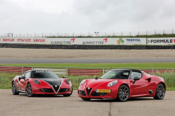 Two red Alfa Romeo 4C Spider cars on a race track