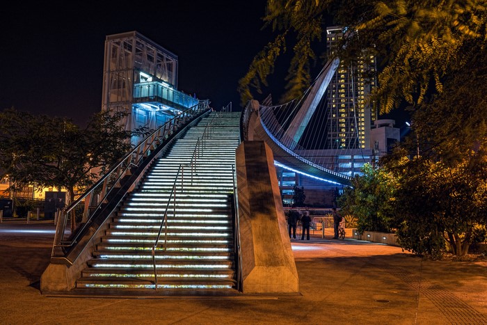 Pedestrian bridge with illuminated stairs at night in San Diego