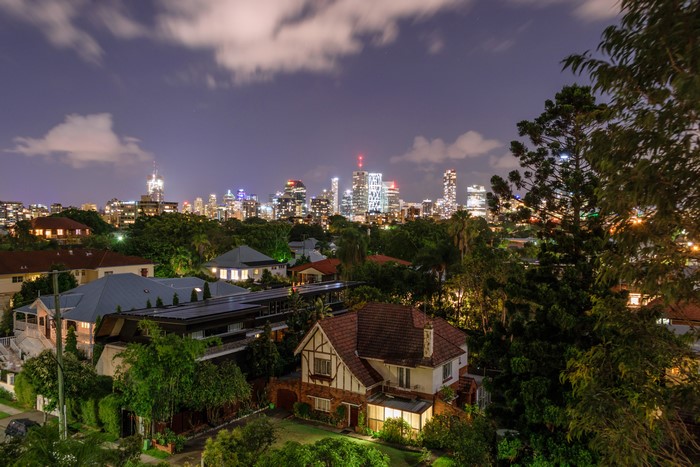 Brisbane skyline at dusk with houses in foreground