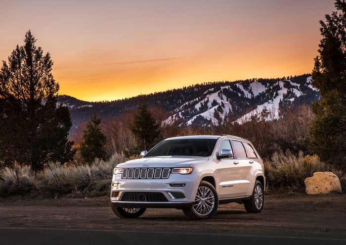 White Jeep Grand Cherokee parked at sunset with mountains