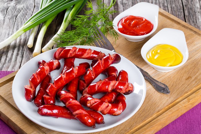 Plate of Vienna sausages with ketchup and mustard