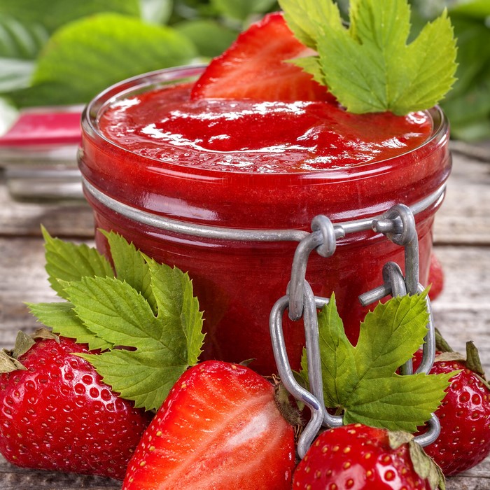 Strawberry jam in a jar with fresh strawberries