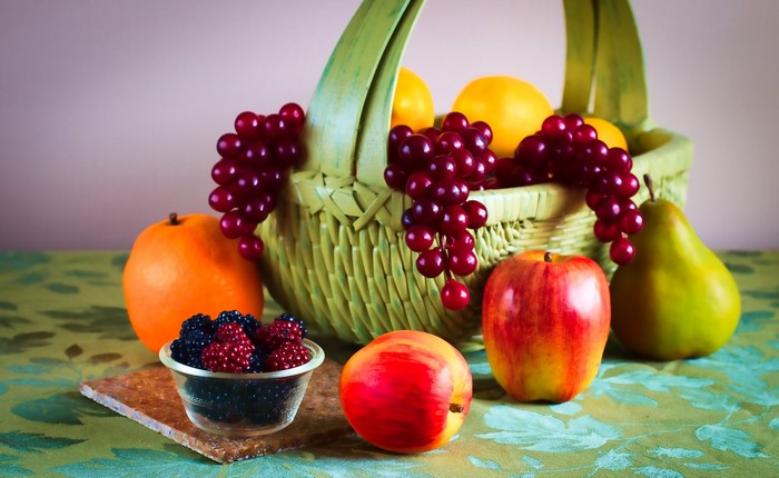 Fruit basket with apples, pears, grapes, berries, and oranges