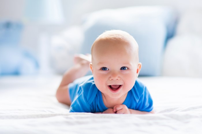 Baby in blue onesie smiling