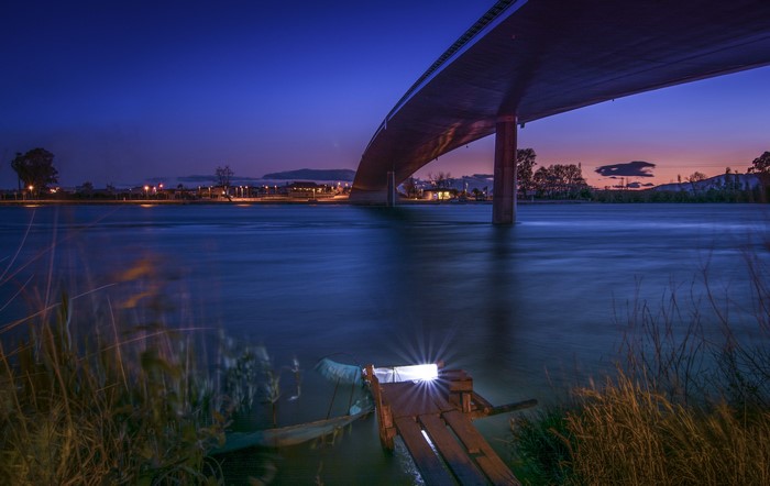 Bridge over river at dusk in Delta del Ebro, Spain