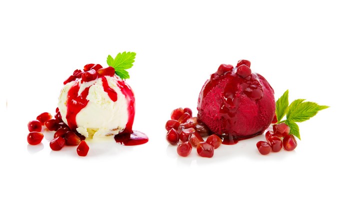 Two scoops of ice cream with pomegranate and mint