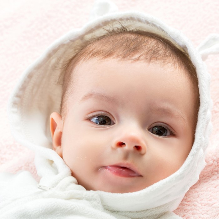 Close-up of a baby's face in a hooded outfit