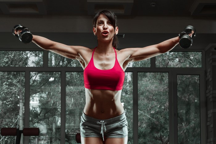 Woman exercising with dumbbells in a gym