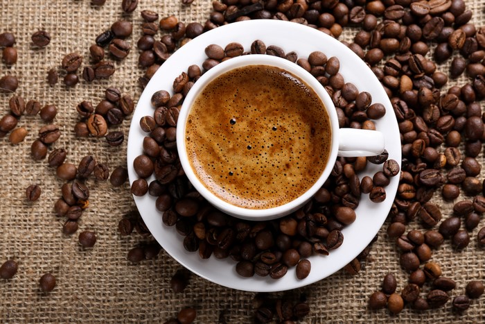 Coffee cup on saucer with coffee beans