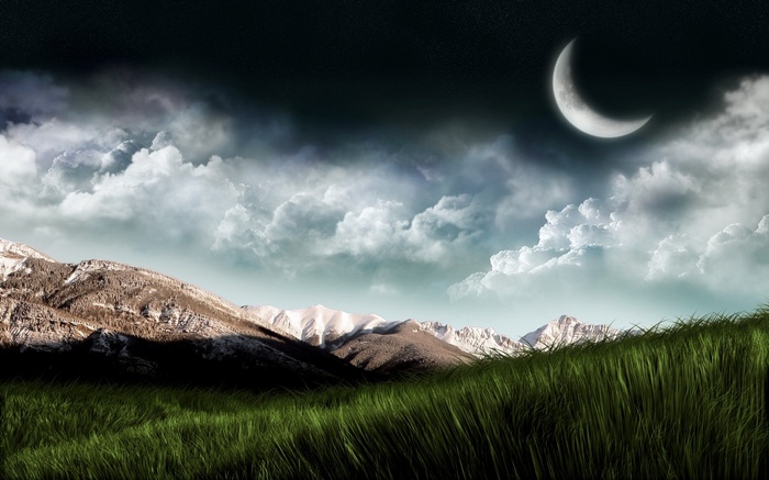 Crescent moon over snowy mountains and grassy field