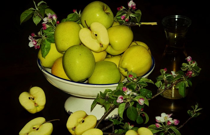 Apples and apple blossoms on black background