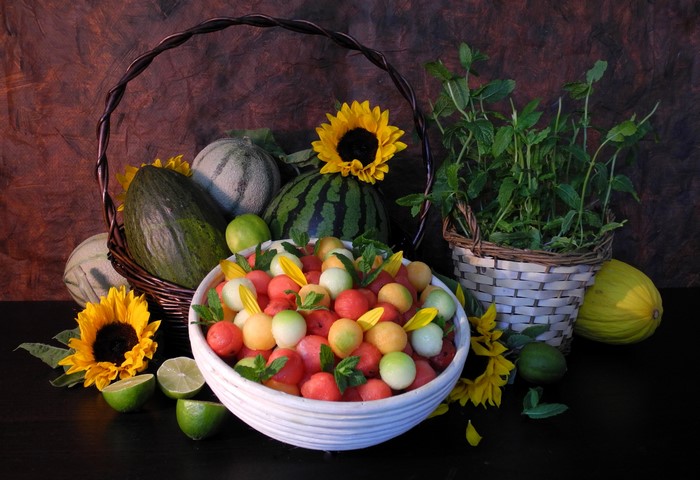 Still-life of assorted melons and sunflowers