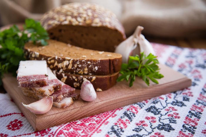 Salo, Bread, Garlic, and Parsley on a Cutting Board