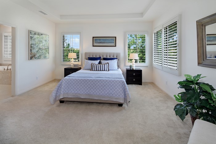 Bedroom with bed, lamps, and windows