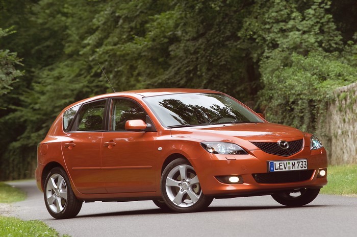 Orange Mazda 3 Hatchback on a Road