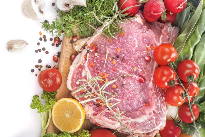 Raw steak with tomatoes, lemon, and herbs