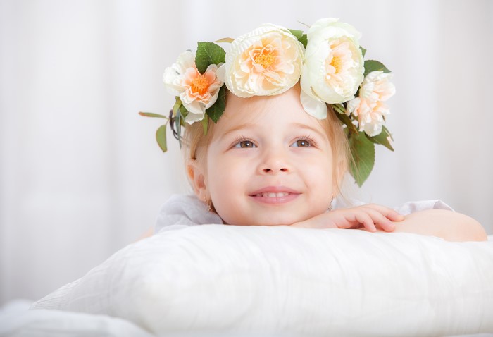 Little girl with flower crown on pillow