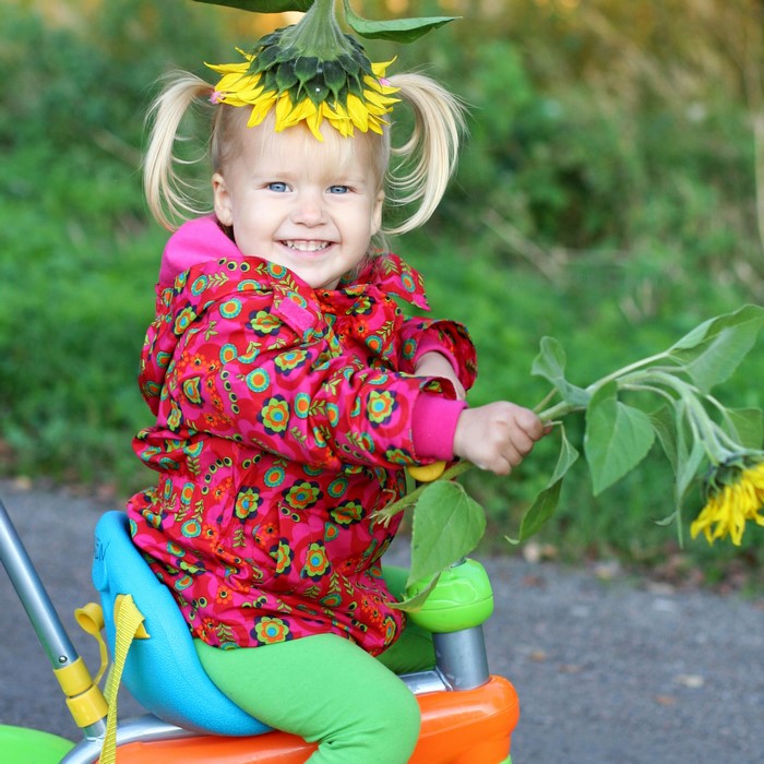 Girl with Sunflower Hat Riding a Tricycle