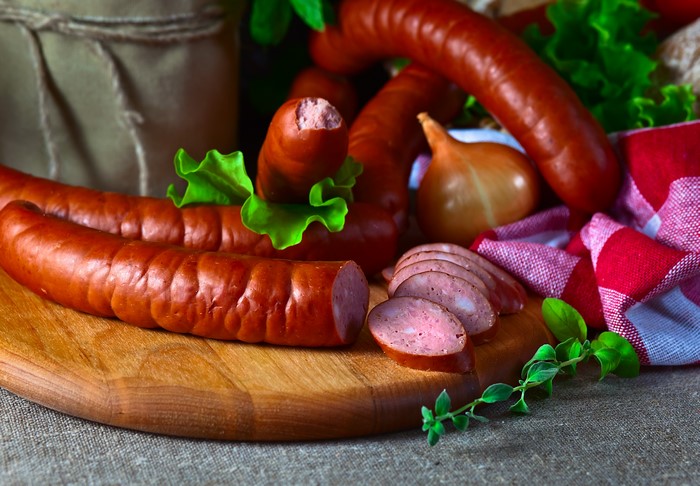 Sausages and onion on a wooden board