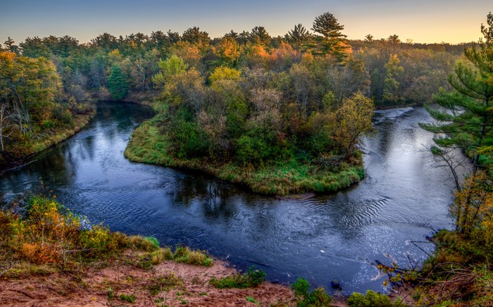 River winding through autumn forest in USA