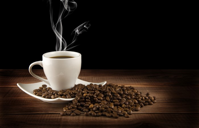 Coffee cup with steam and coffee beans