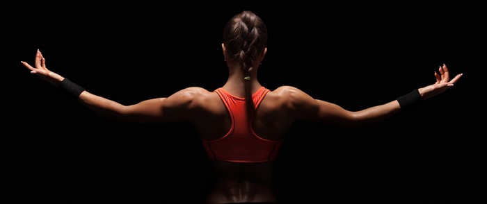 Woman with braid and orange top on black background