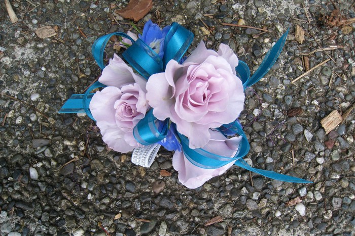 Purple roses corsage with blue and teal ribbon
