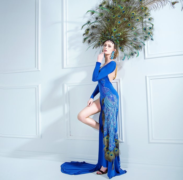 Woman in blue dress with peacock feathers