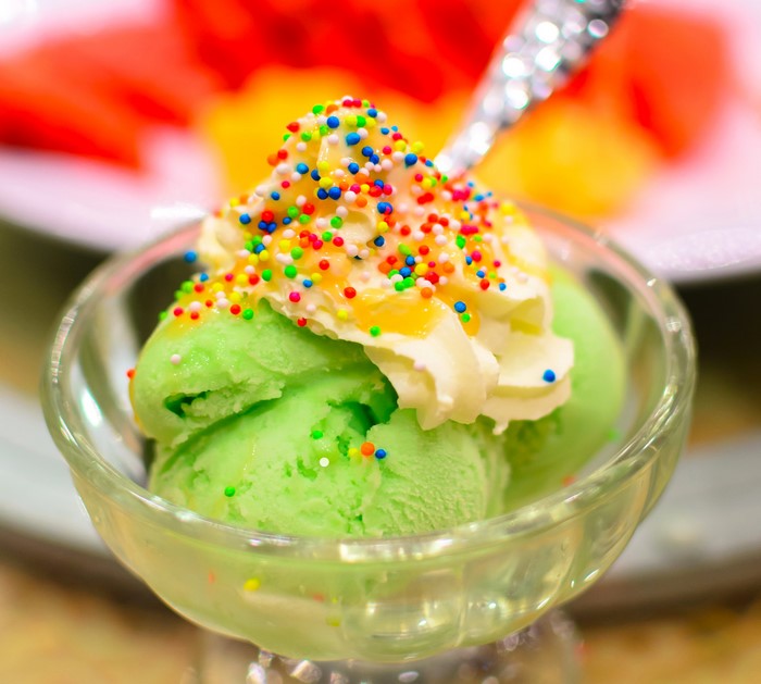 Green ice cream with whipped cream and sprinkles