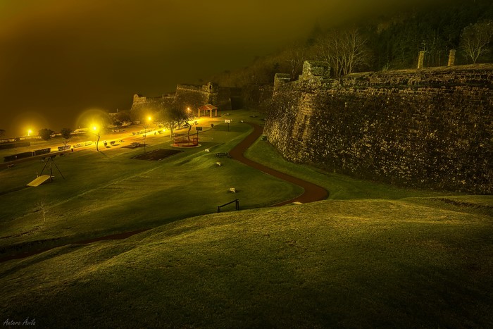 Fortress at night with street lights and lawn