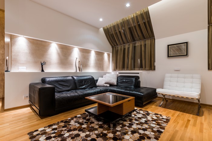 Modern living room with black leather sofa and white chair