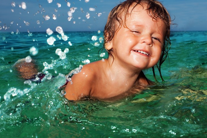 Cute boy splashing in the ocean