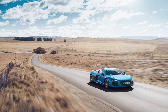 Blue Audi R8 V10 driving on a rural road