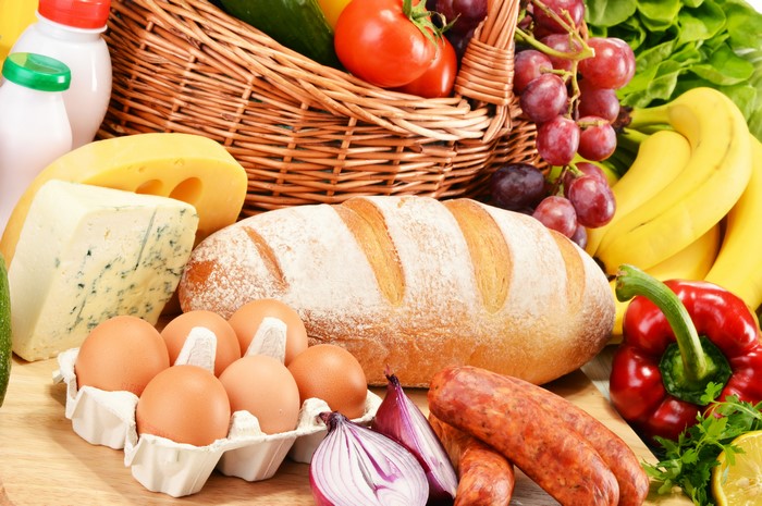 Assortment of Food: Bread, Cheese, Sausage, Eggs, Fruits, and Vegetables