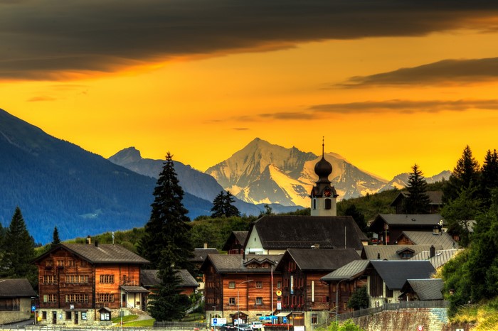 Village with church and mountains at sunset, Blitzingen Goms, Switzerland