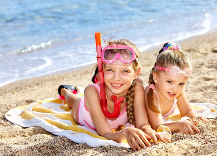 Two Little Girls Relaxing on Beach with Snorkel Gear