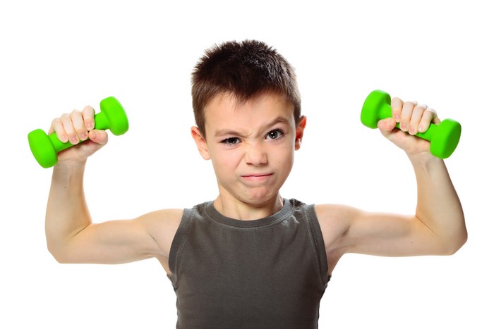 Boy with green dumbbells on white background