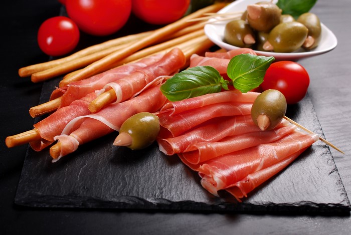 Prosciutto with breadsticks, olives, and tomatoes