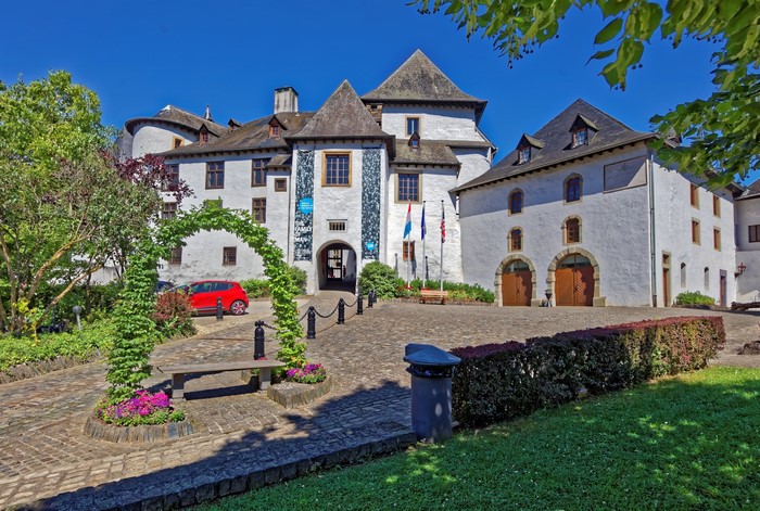 Clervaux Castle in Luxembourg with a red car